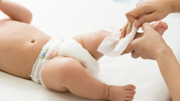 Mother cleaning up and wipes body and leg baby by wet tissue
